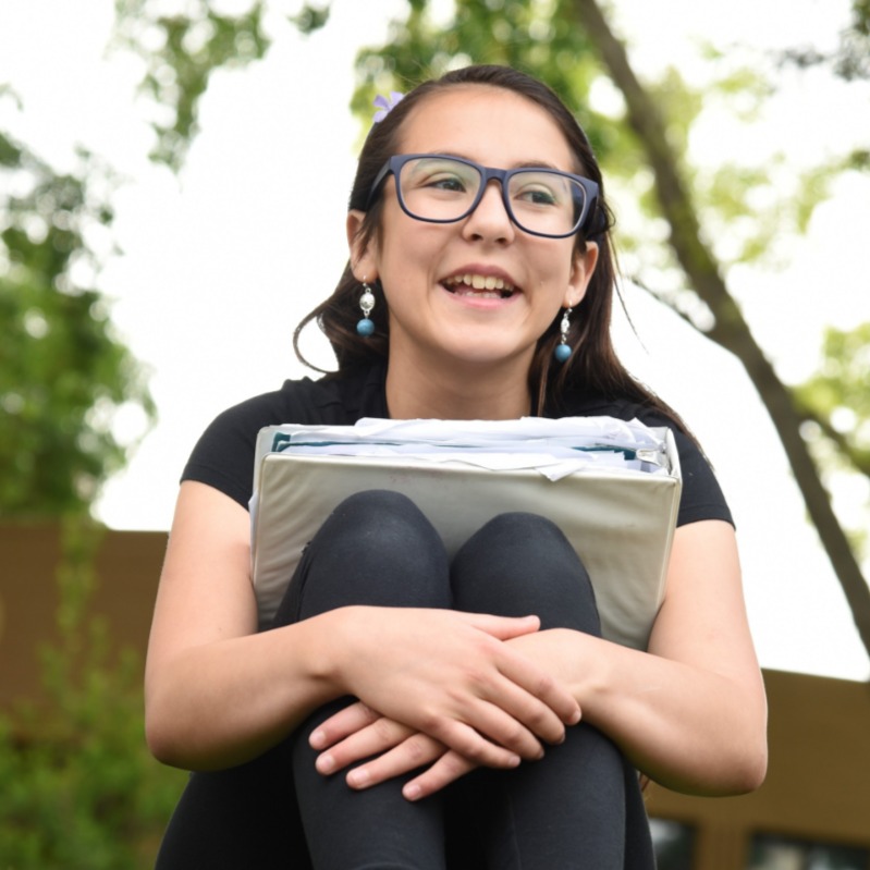student smiling with binder