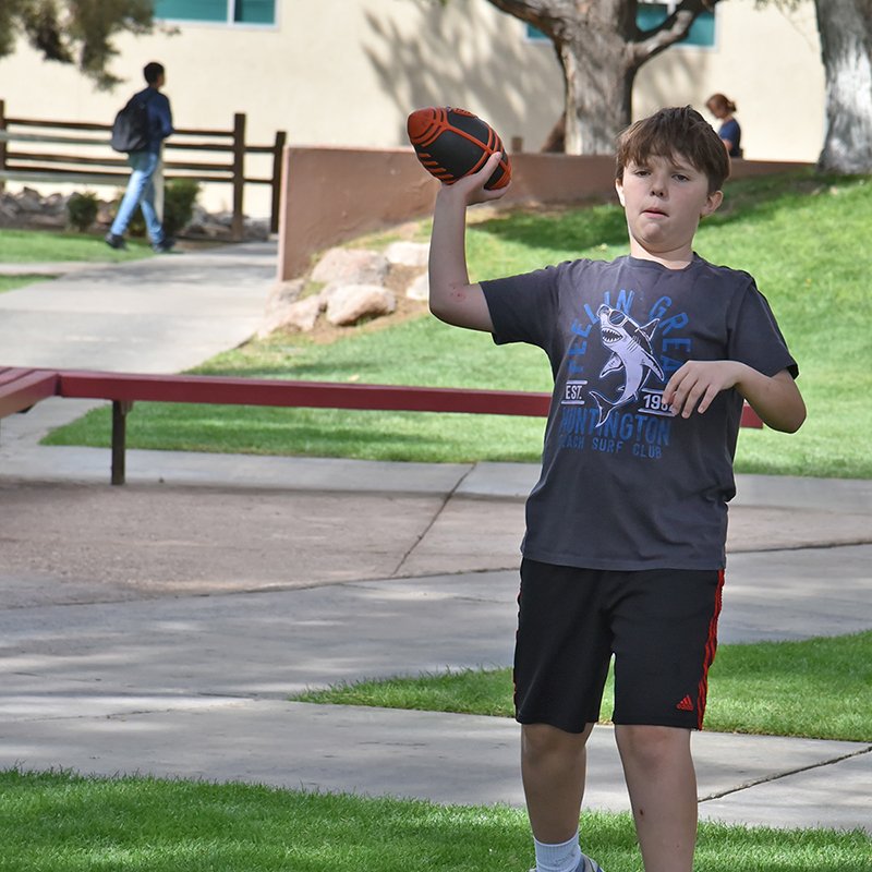 Student throws football during lunch