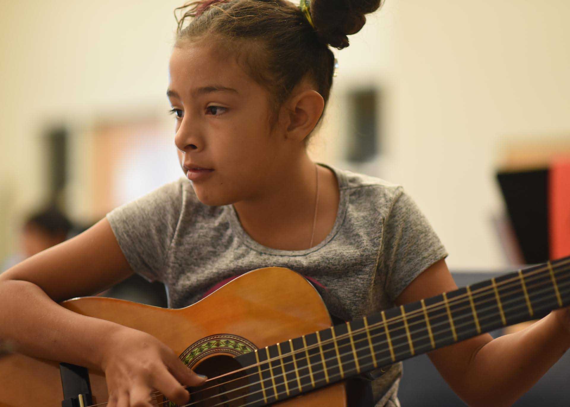 Young camper playing guitar 