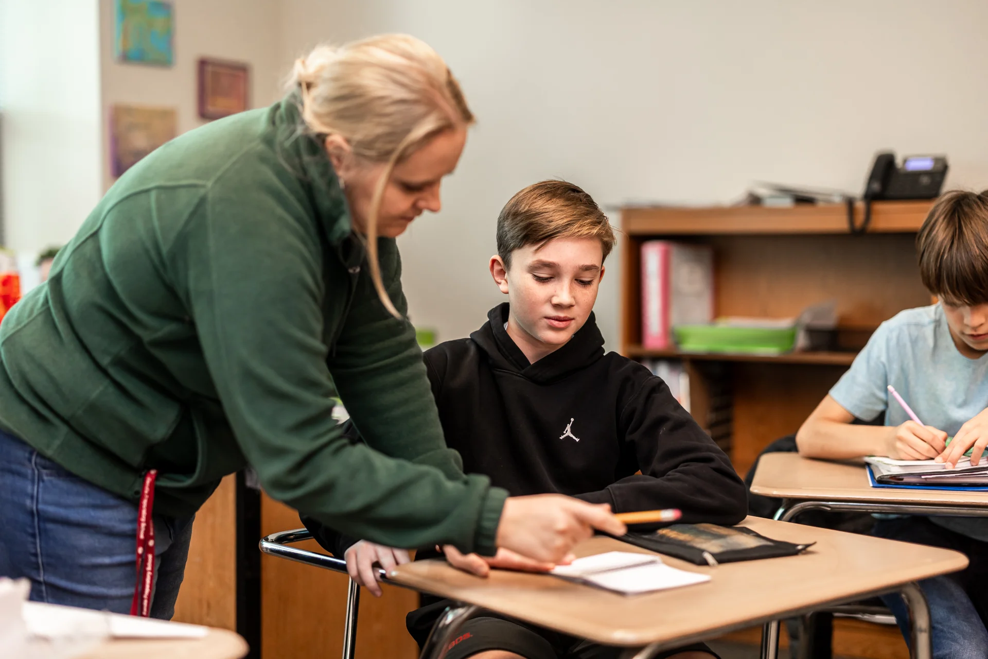 Teacher helping student in classroom
