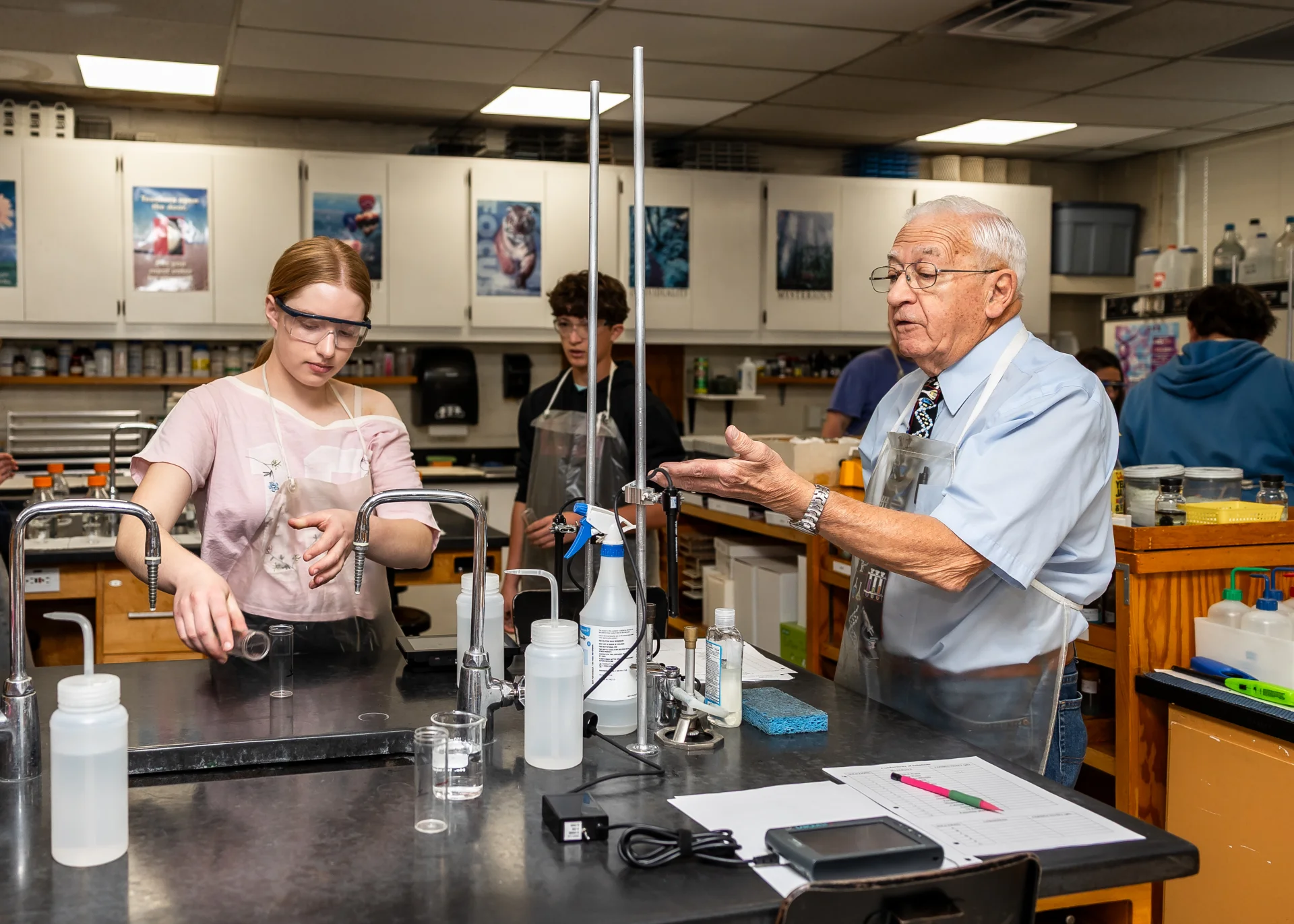 Science teacher working with student in lab 