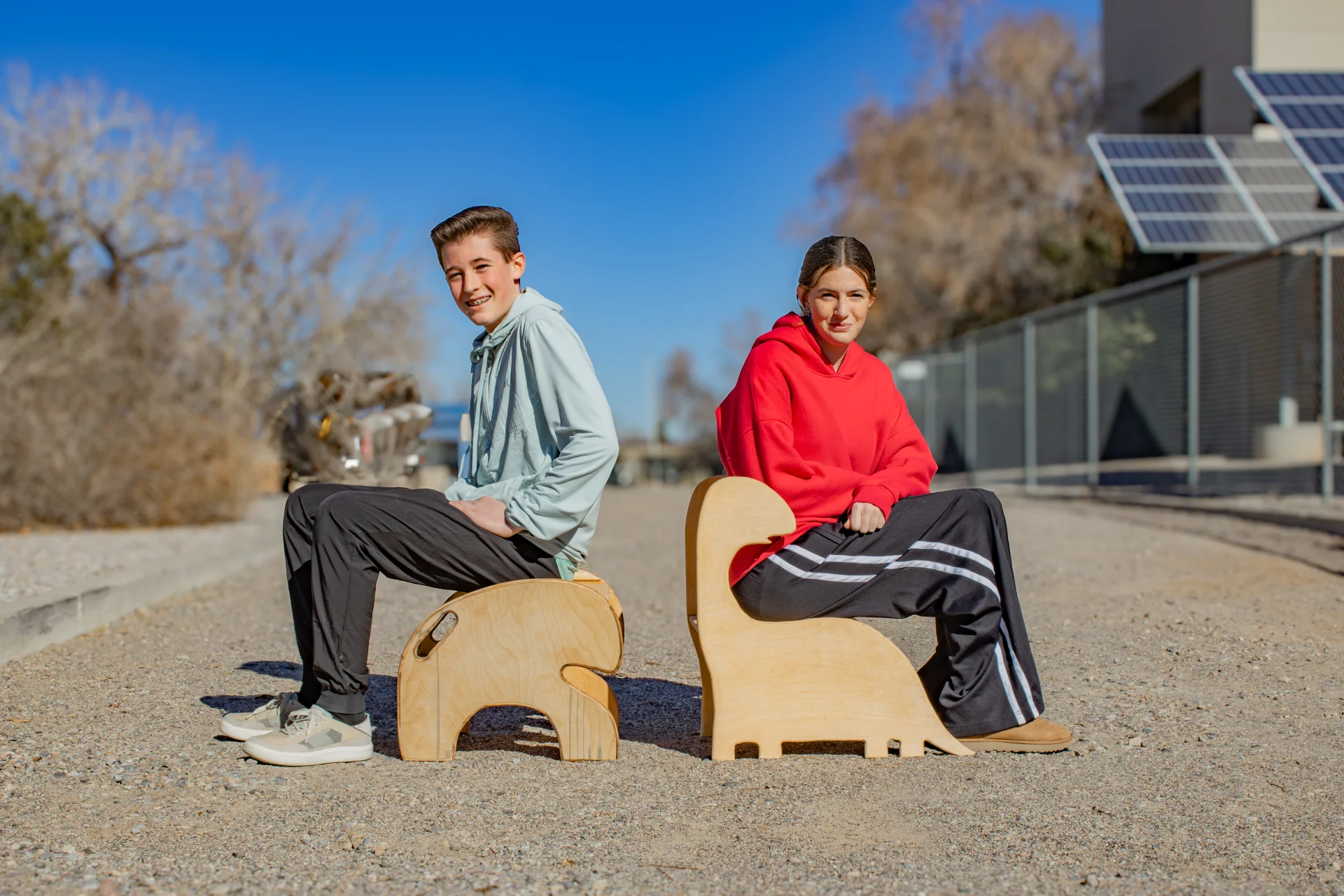 Two students sitting on the step stools they created