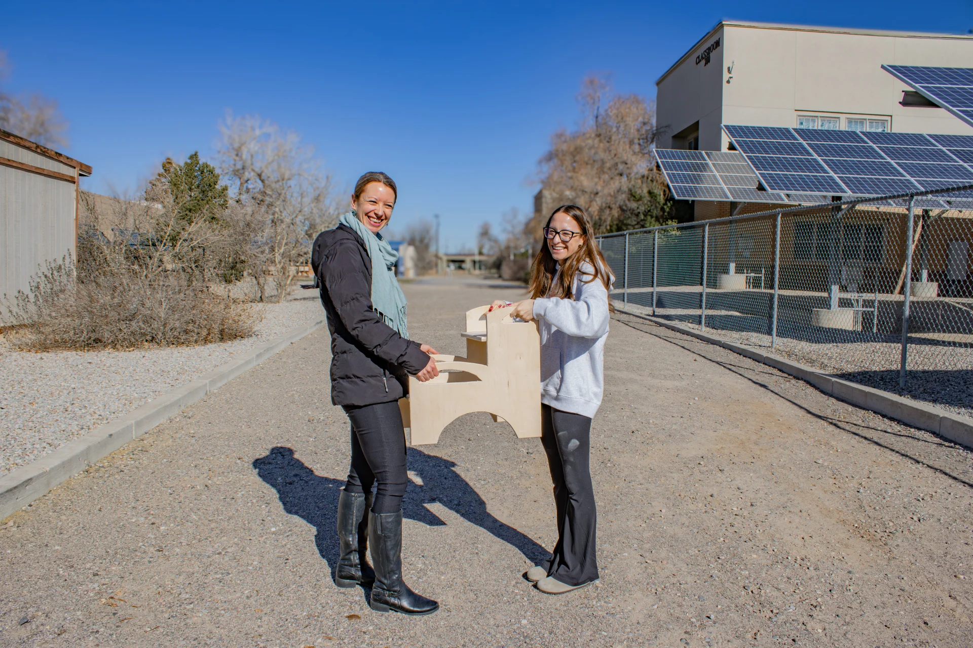 Student presenting step stool to Saranam representative