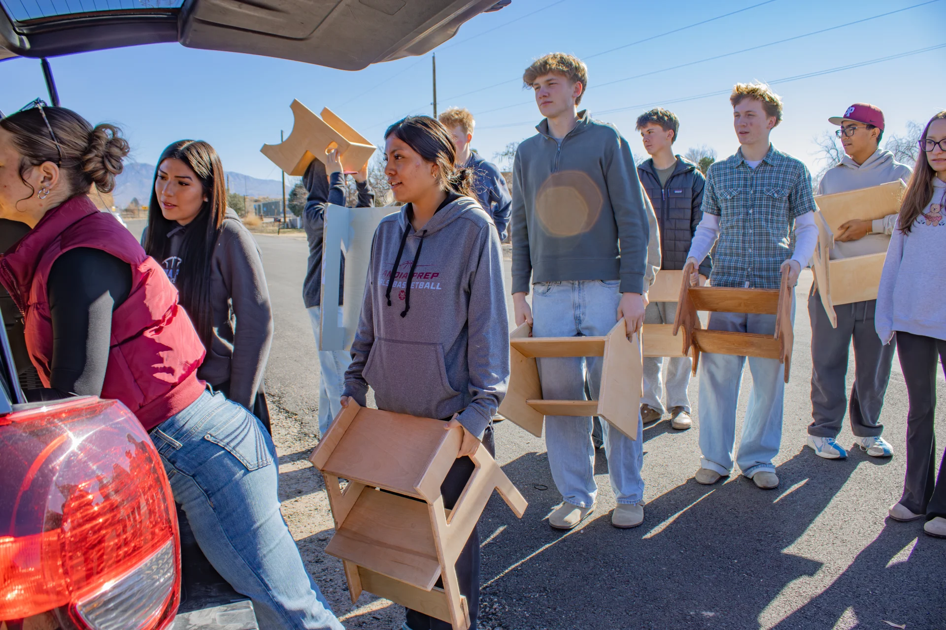 Students loading step stools into car