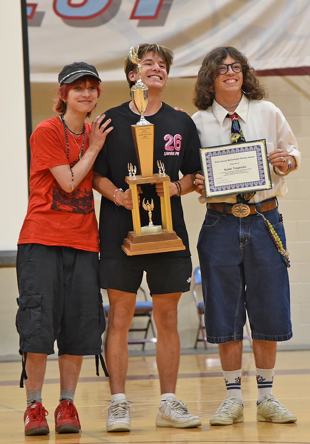 Two students presenting award to another student
