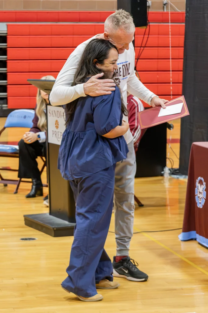 Woman accepting award from coach.