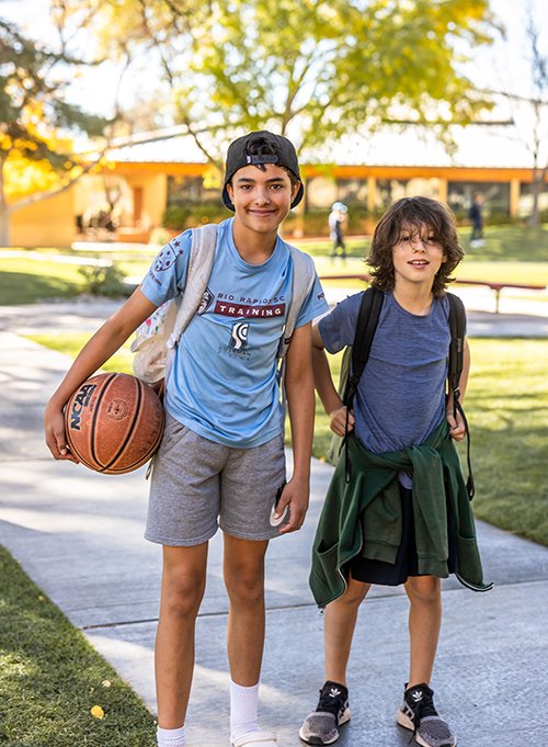 two students on quad with a basketball