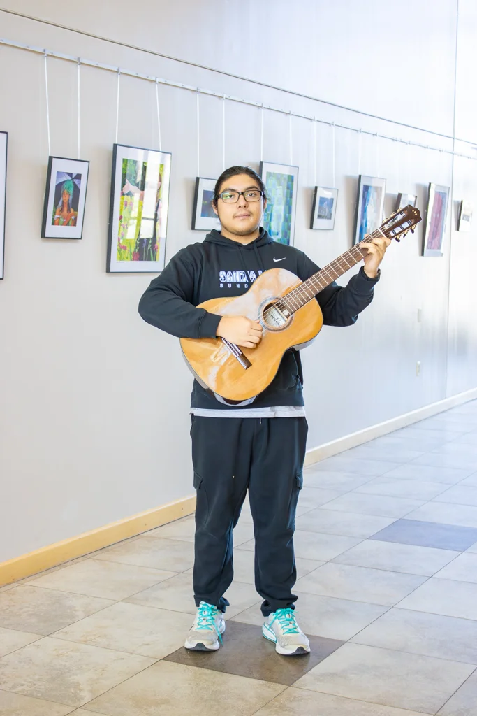 student Avery playing guitar