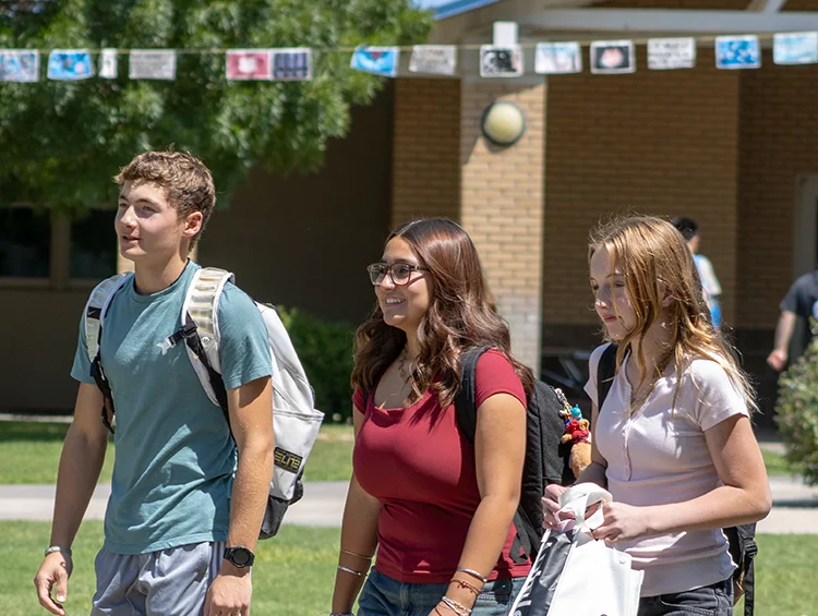 3 students walking on quad