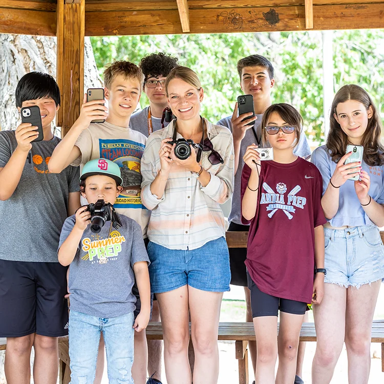 campers with instructor posing with cameras