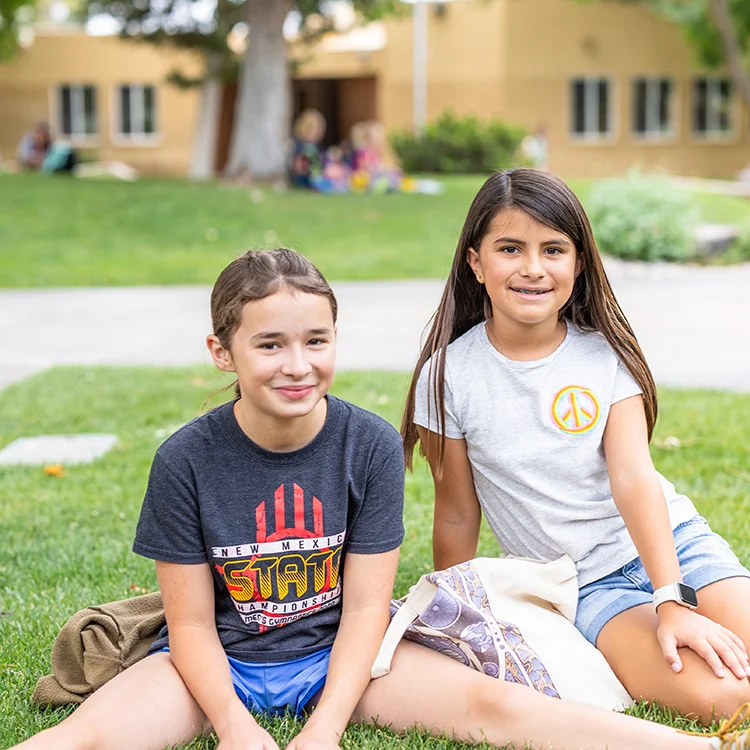 two smiling campers on campus