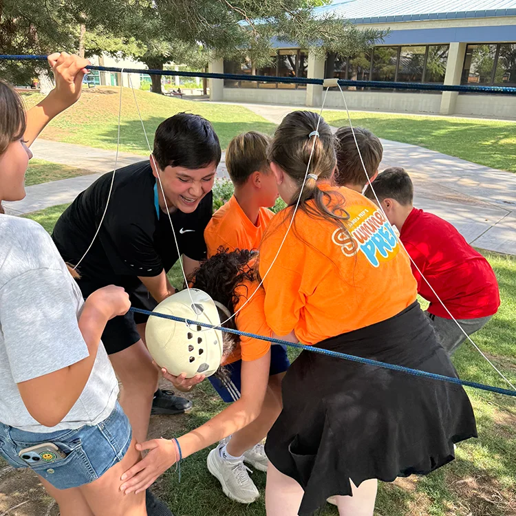 campers putting together rope bridge