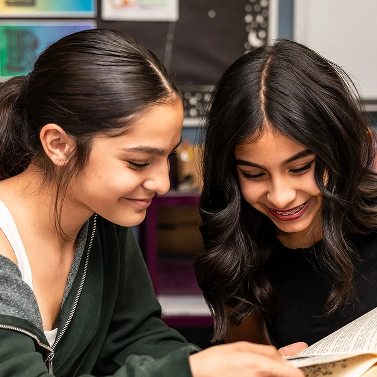 students working together and reading a book